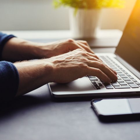 Man typing on laptop in the office, toned image