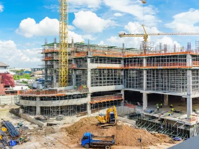 Construction site and unfinished high-rise building with scaffolding, Yellow tower crane and blue sky cloudy.